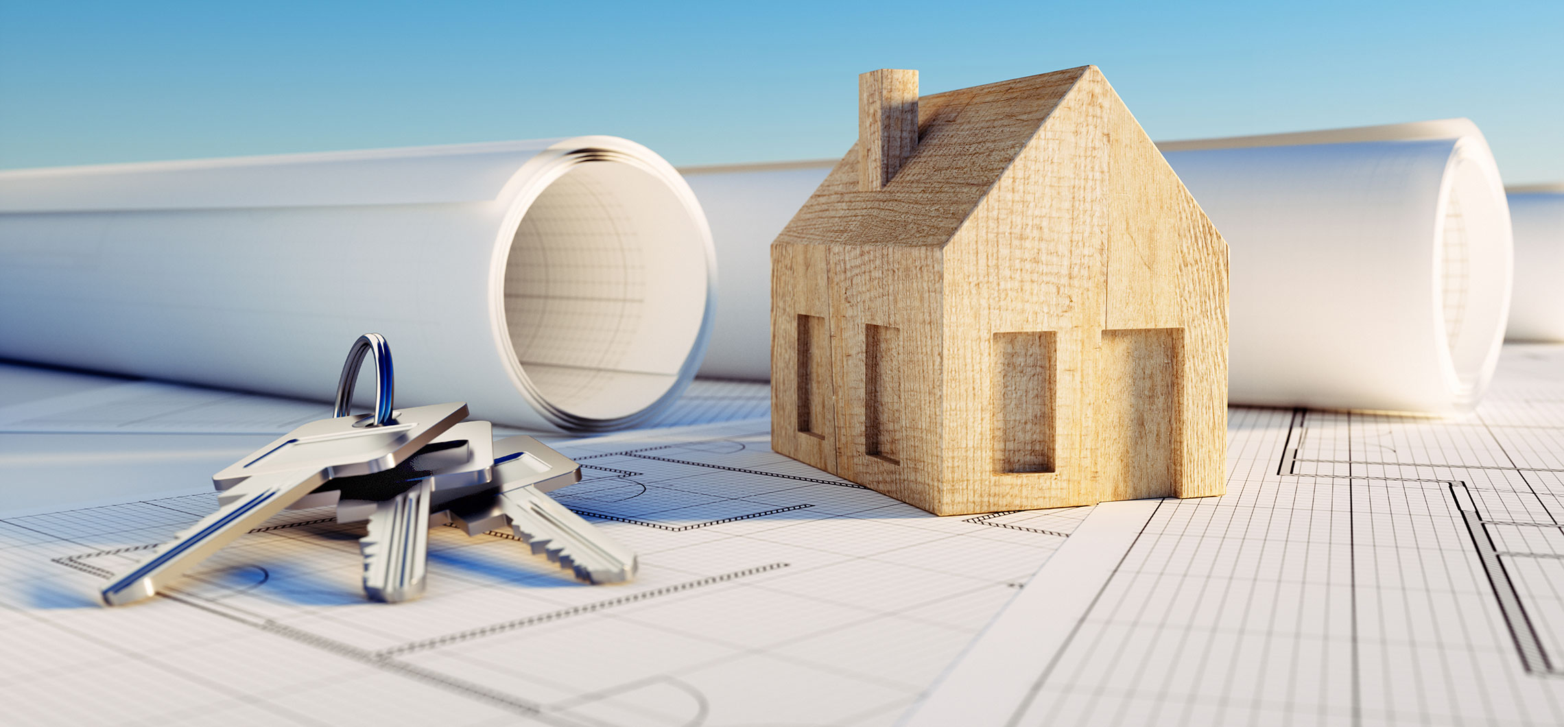 Ein Modellhaus neben Bauplänen und einem Schlüsselbund