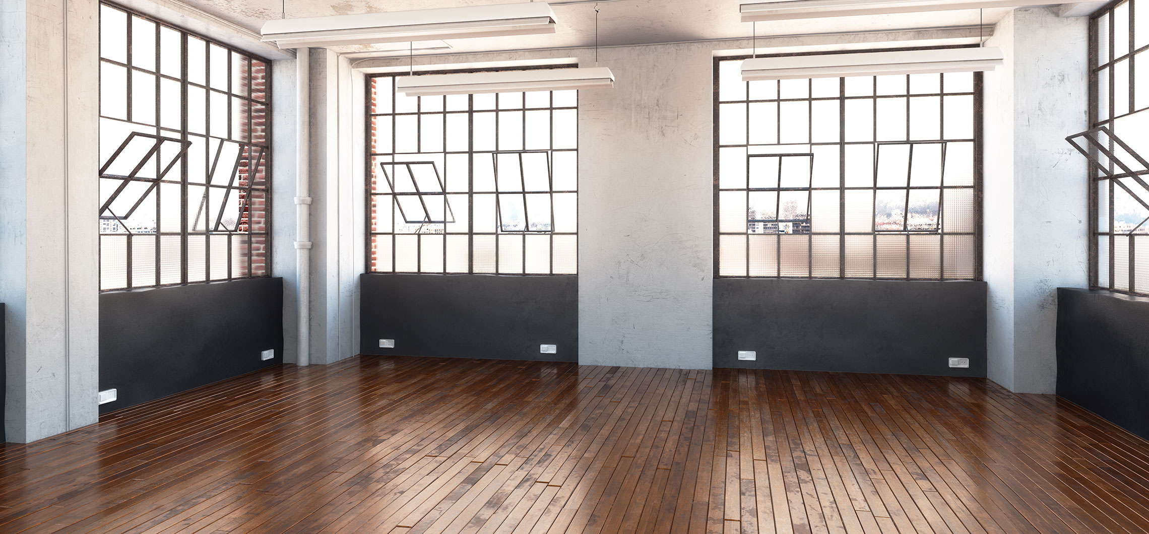 Ein leerer Raum mit Parkettboden und großen Fenstern