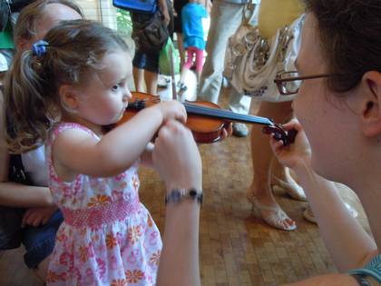 Ein Kind probiert eine Geige aus.