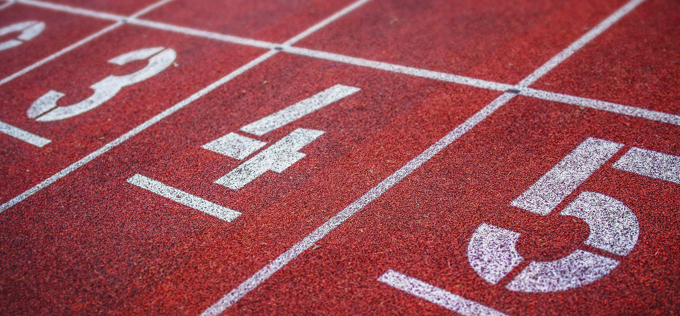 Nahaufnahme einer Tartanbahn auf einem Sportplatz