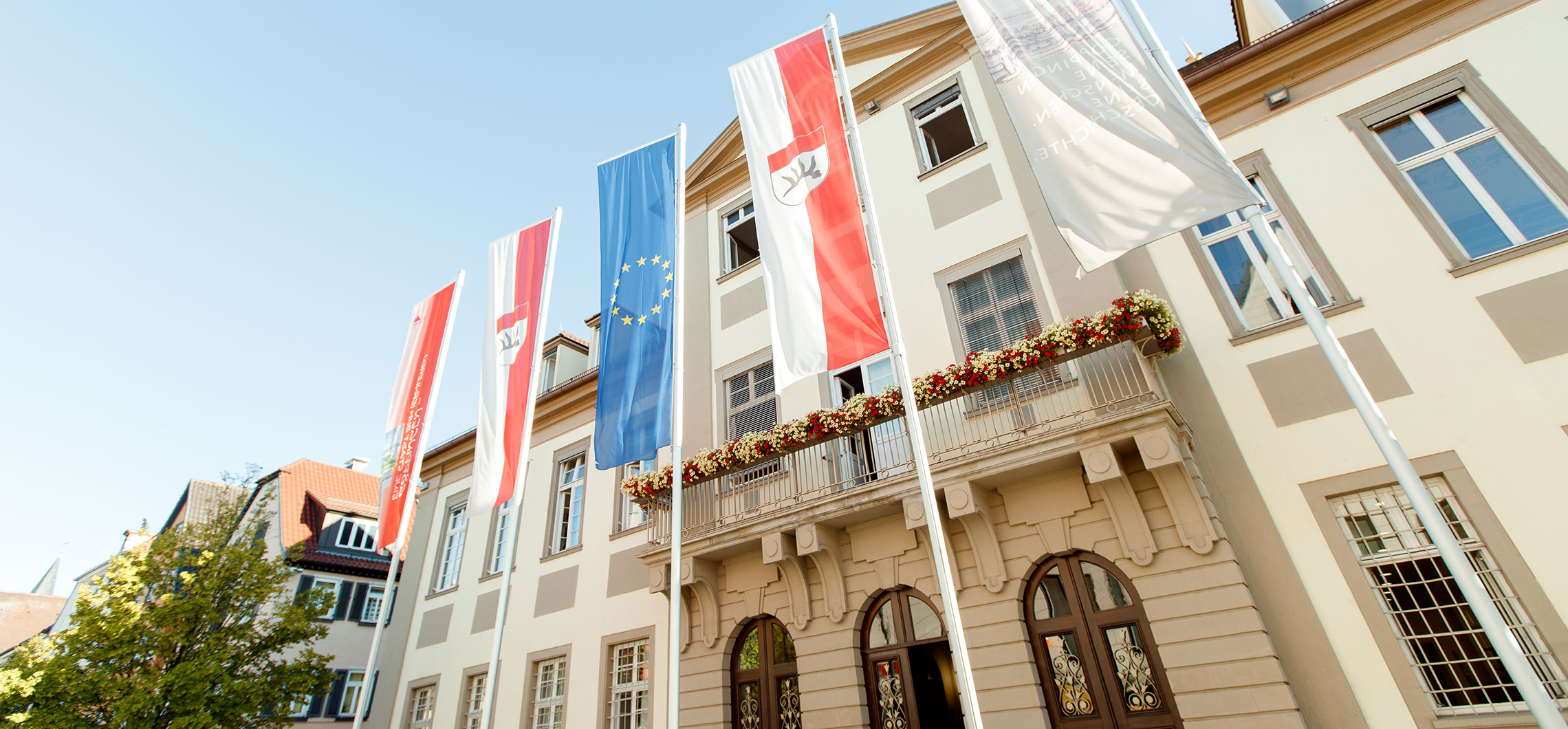 Das Rathaus Göppingen mit Beflaggung vor einem blauen Himmel