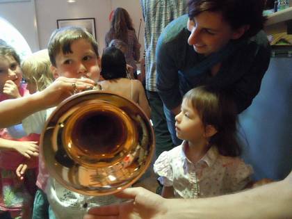 Mehrere Kinder begutachten ein Blasintrument