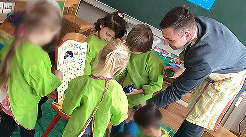 Erster Bürgermeister Johannes Heberle bemalt mit Kindern einen Stuhl