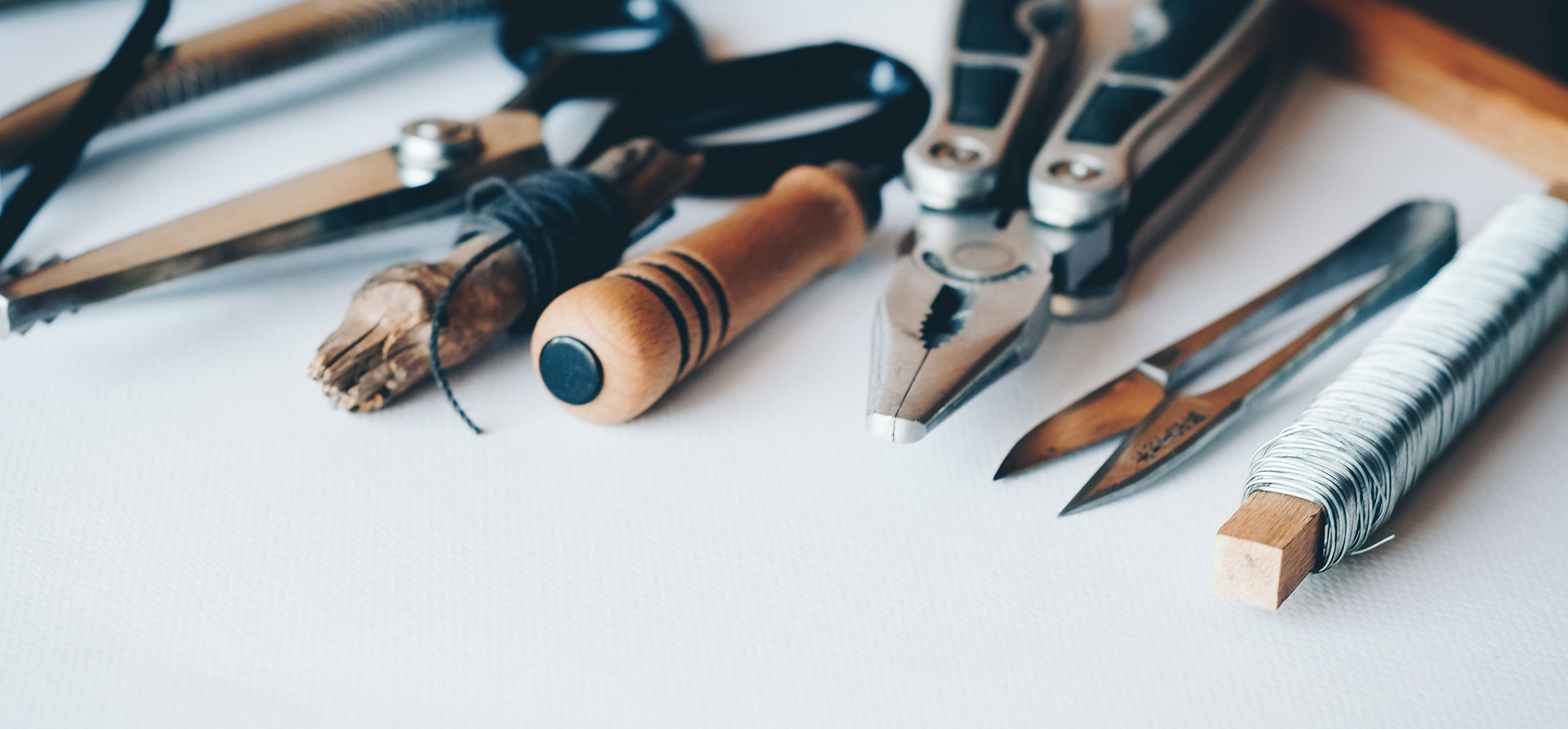 Mehrere Werkzeuge liegen auf einer Werkbank nebeneinander