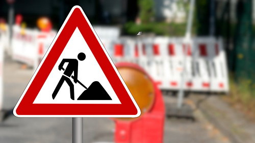 Ein Baustellenschild vor Straßenabsperrungen