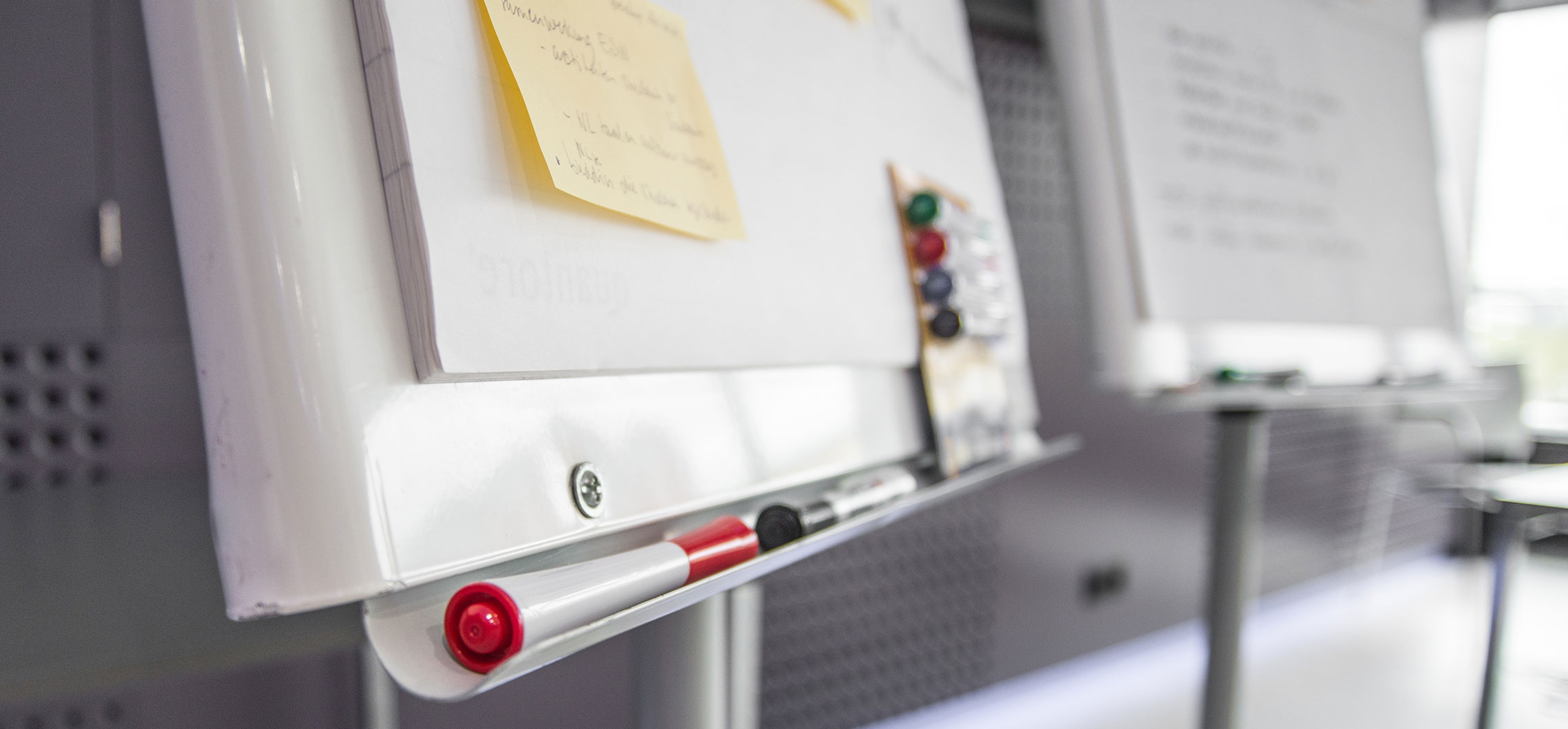 Ein Whiteboard mit Stiften, Magneten und Papier