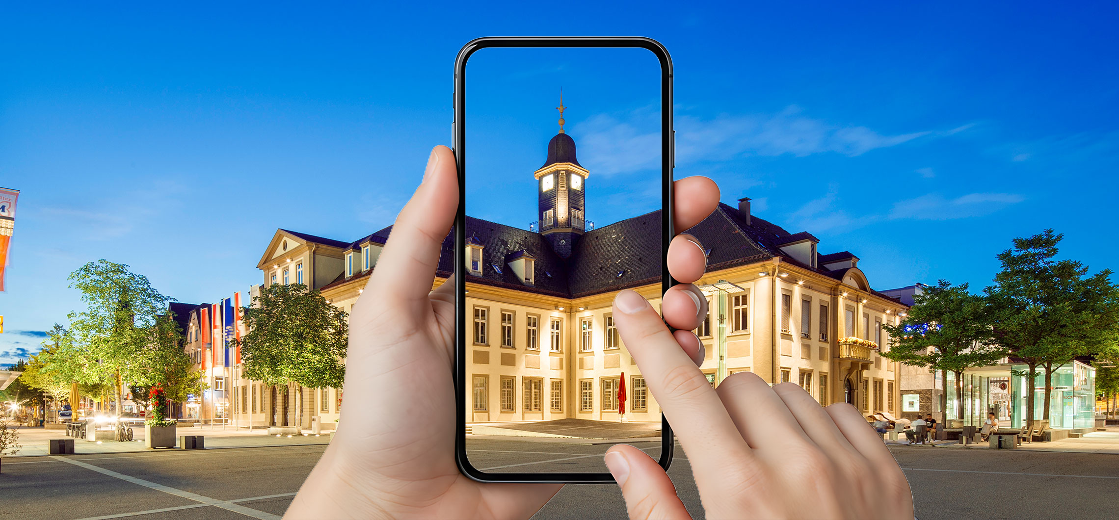 Ein Smartphone wird vor das Rathaus in Göppingen gehalten