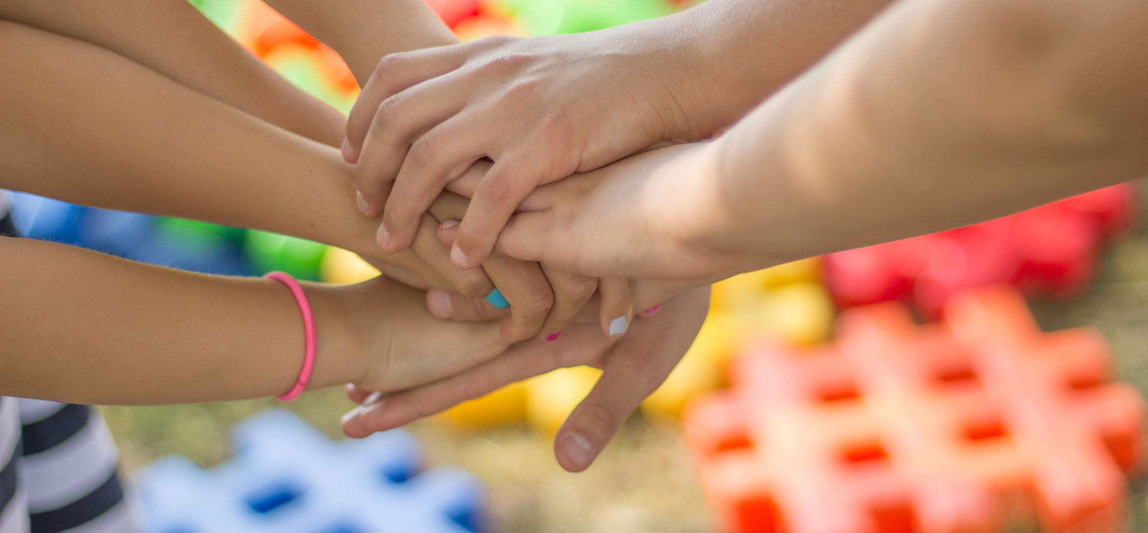 Mehrere Kinder die ihre Hände übereinander legen.