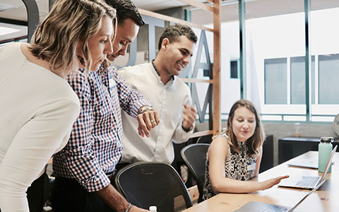 Junge Menschen schauen gemeinsam auf den Bildschirm eines Laptops