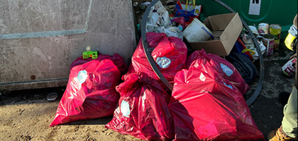 Mehrere Abfallsäcke liegen vor Altglascontainern