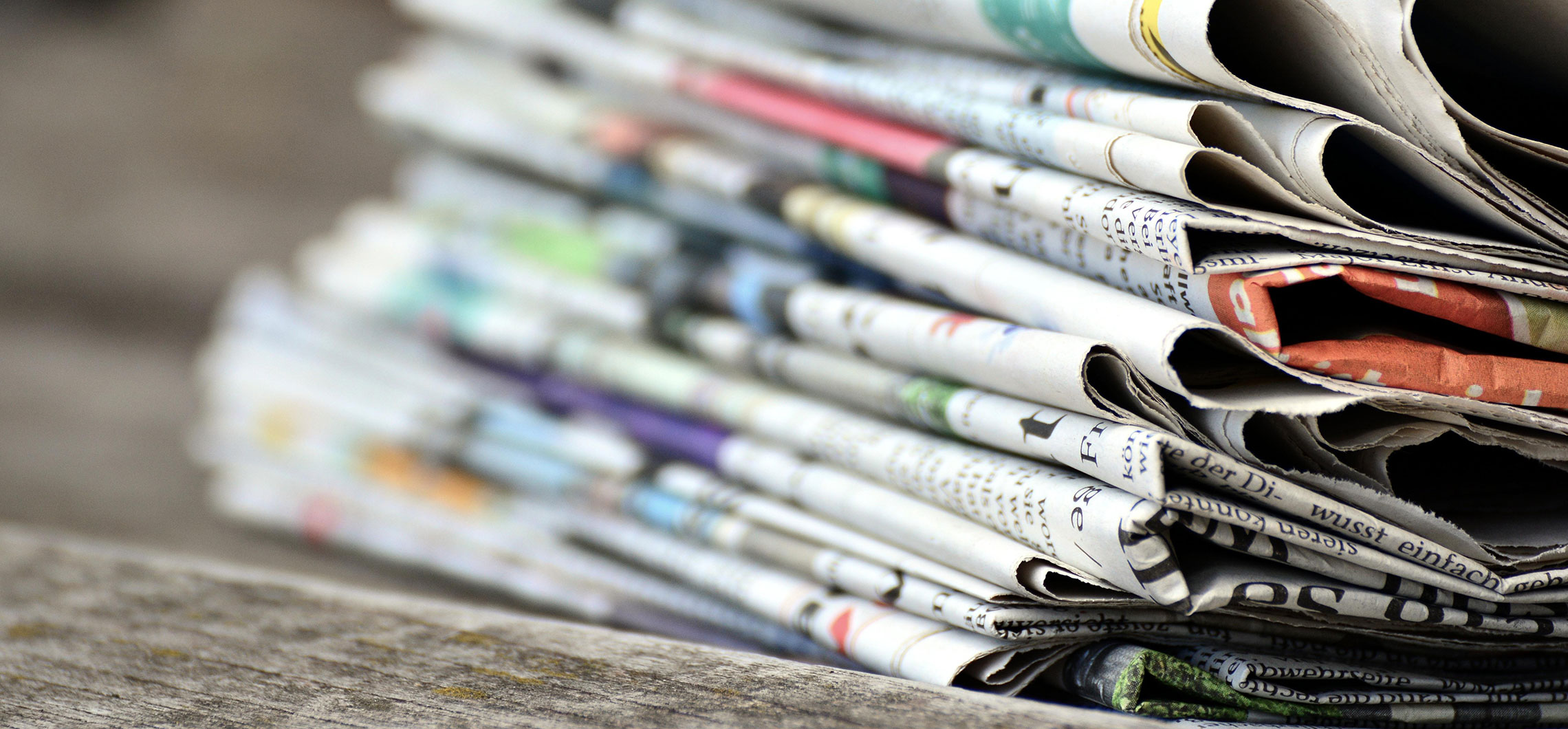 Mehrere Zeitungen liegen gestapelt übereinander