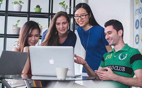 Junge Menschen schauen gemeinsam auf den Bildschirm eines Laptops